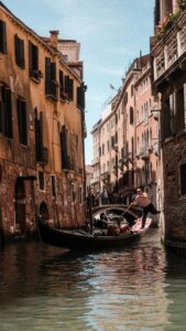 A serene Venetian gondola ride along a canal with centuries old architecture.