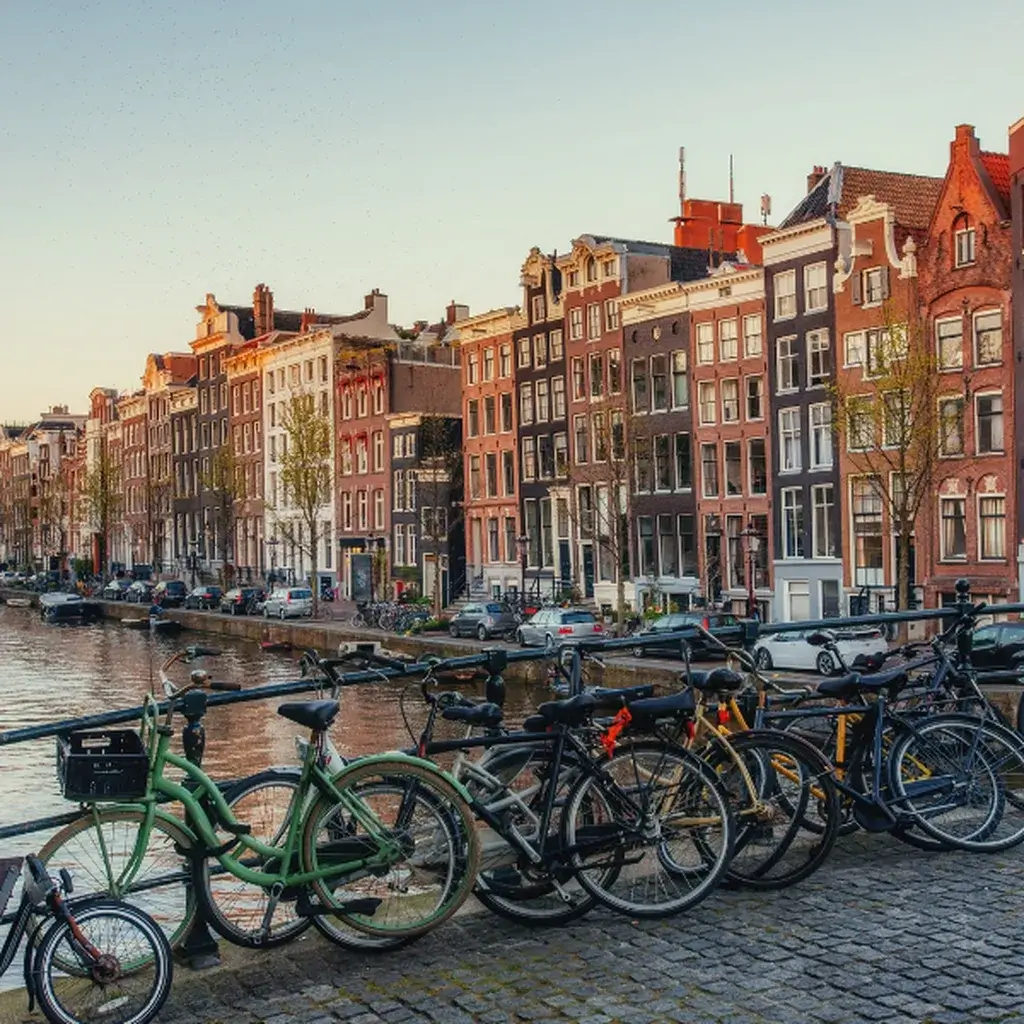 Bicycles parked on a bridge over a scenic canal in Amsterdam, Netherlands