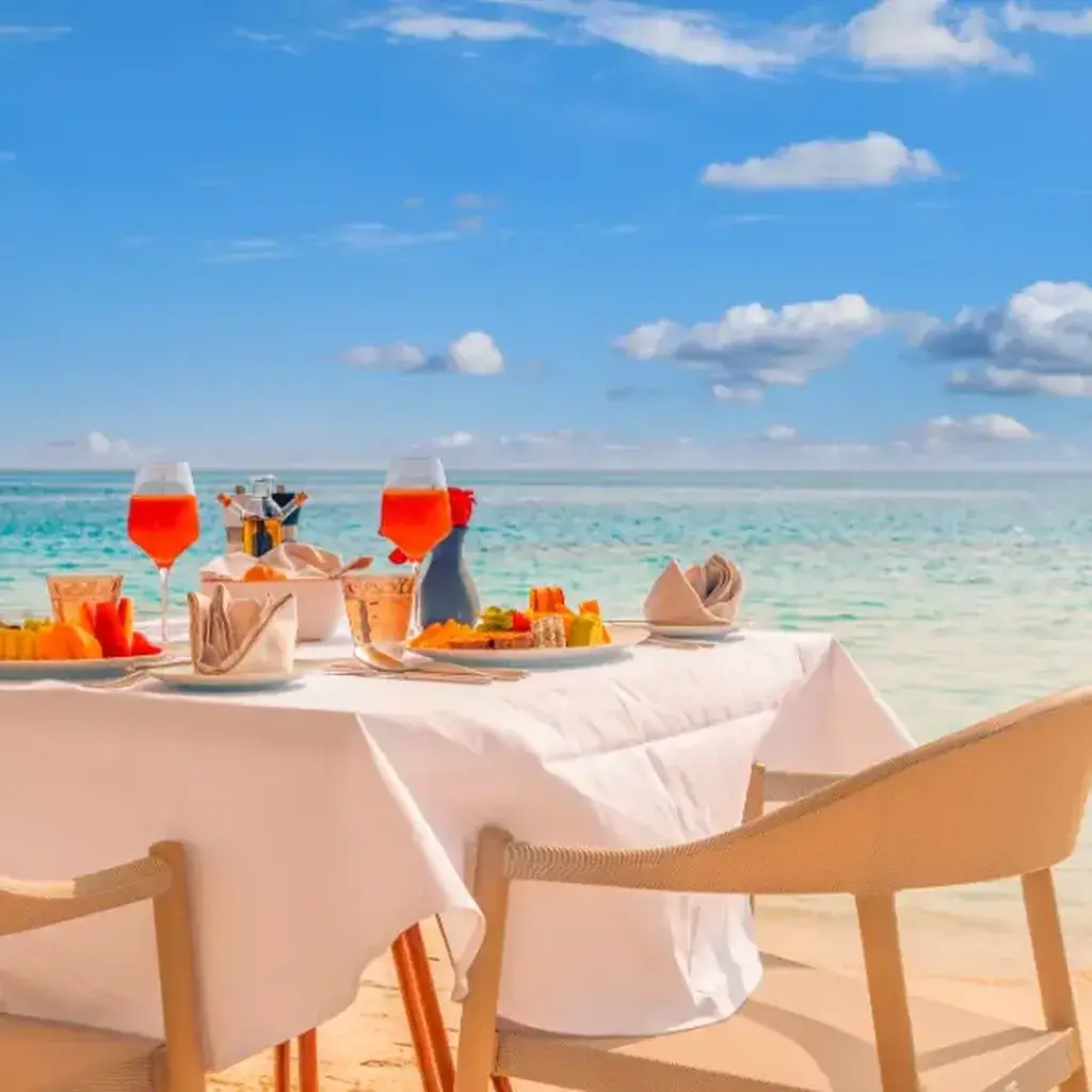 Colorful tropical drinks and a fresh seafood meal on a beautiful sandy beach in Aruba