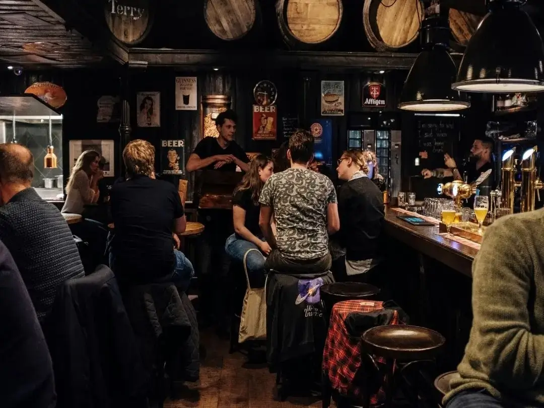 A custom guided tour group dining with locals and enjoying a pint in a traditional Irish pub.