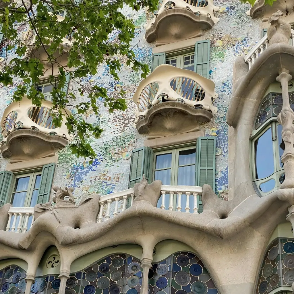 The unique, wavy architecture and colorful mosaic balconies of Casa Batlló in Barcelona, Spain.