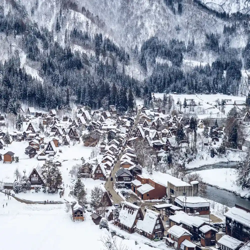 Snow-covered traditional thatched-roof houses in the historic mountain village of Shirakawa-go, Japan.