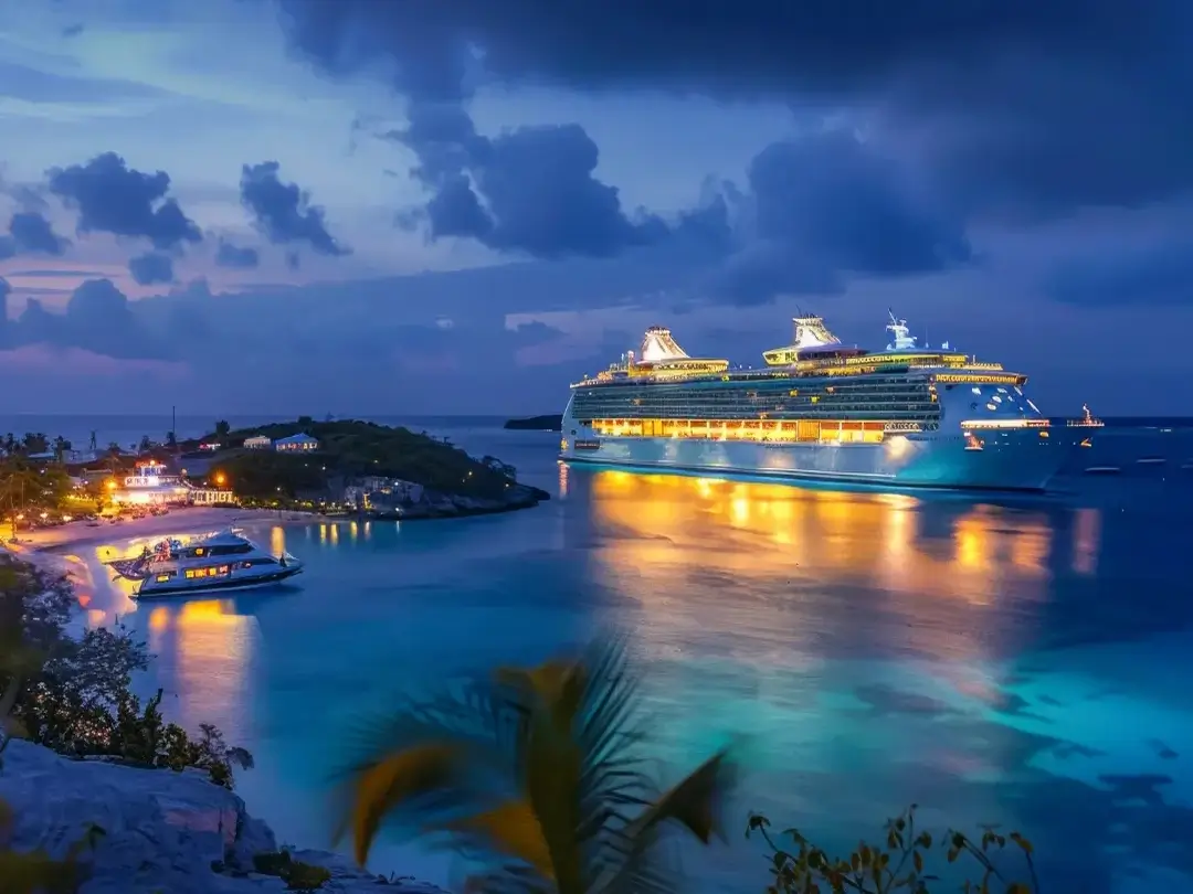A luxury Caribbean cruise ship lit up at evening
