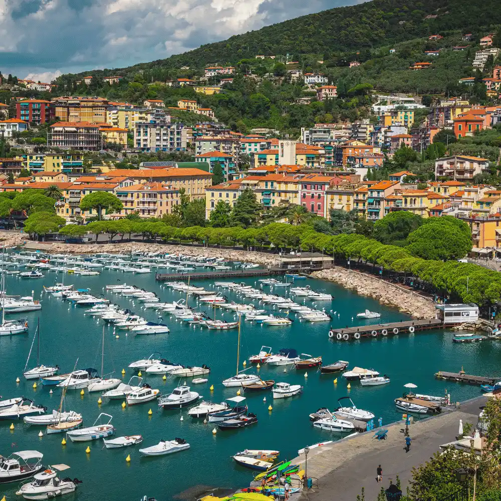 Aerial view of the picturesque coastal town of Lerici, Italy, showing colorful buildings and a harbor full of moored boats.